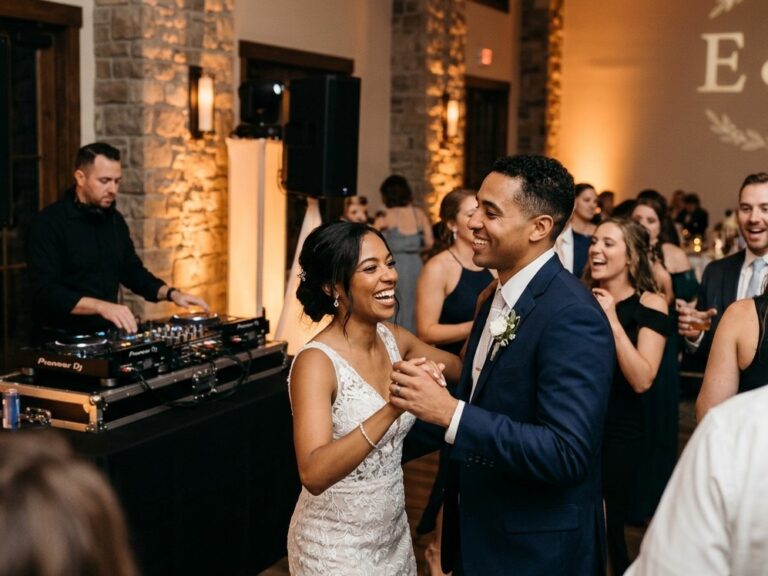 A smiling bride and groom dancing on a packed dance floor during a wedding reception with a professional wedding DJ and custom monogram lighting in Rochester NY.
